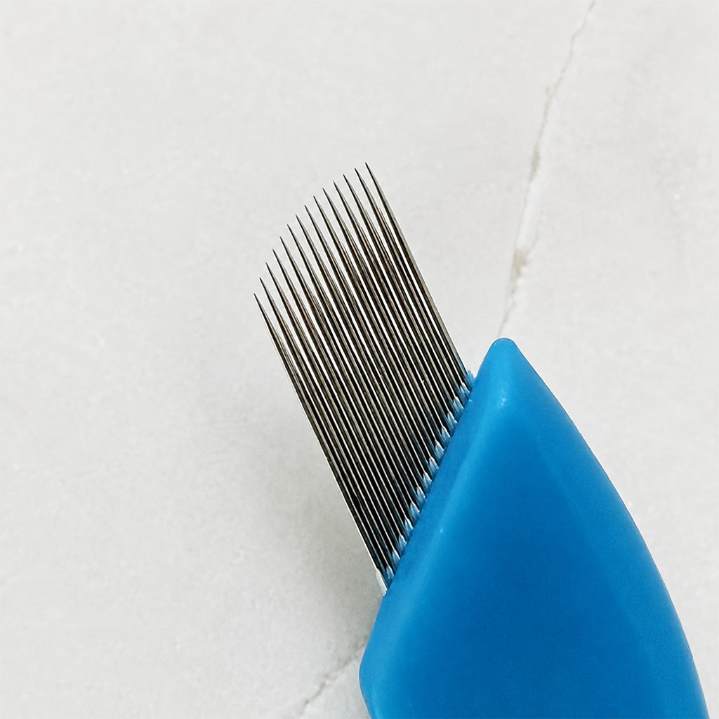 Close-up of SofTap permanent makeup 14 curve regular gauge needle shown against a light textured background.