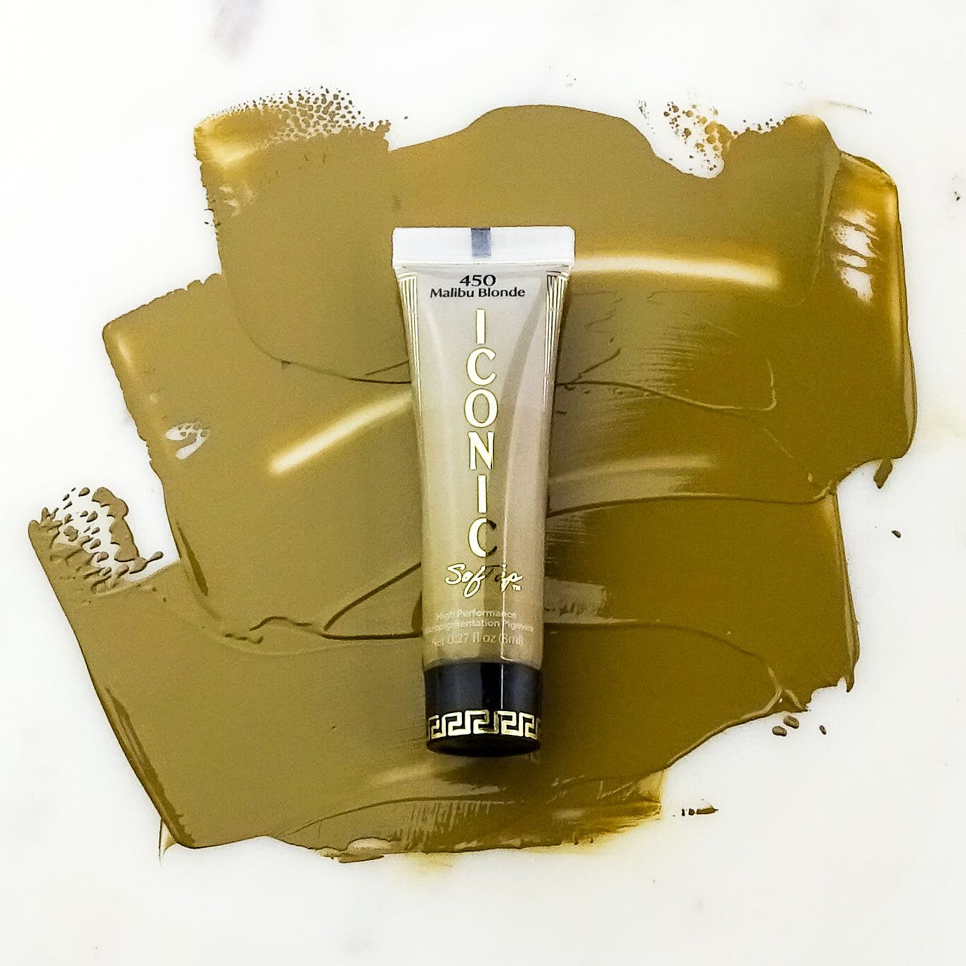 Tube of 'Iconic' Malibu Blonde SofTap Brow permanent cosmetic product on a golden color swatch