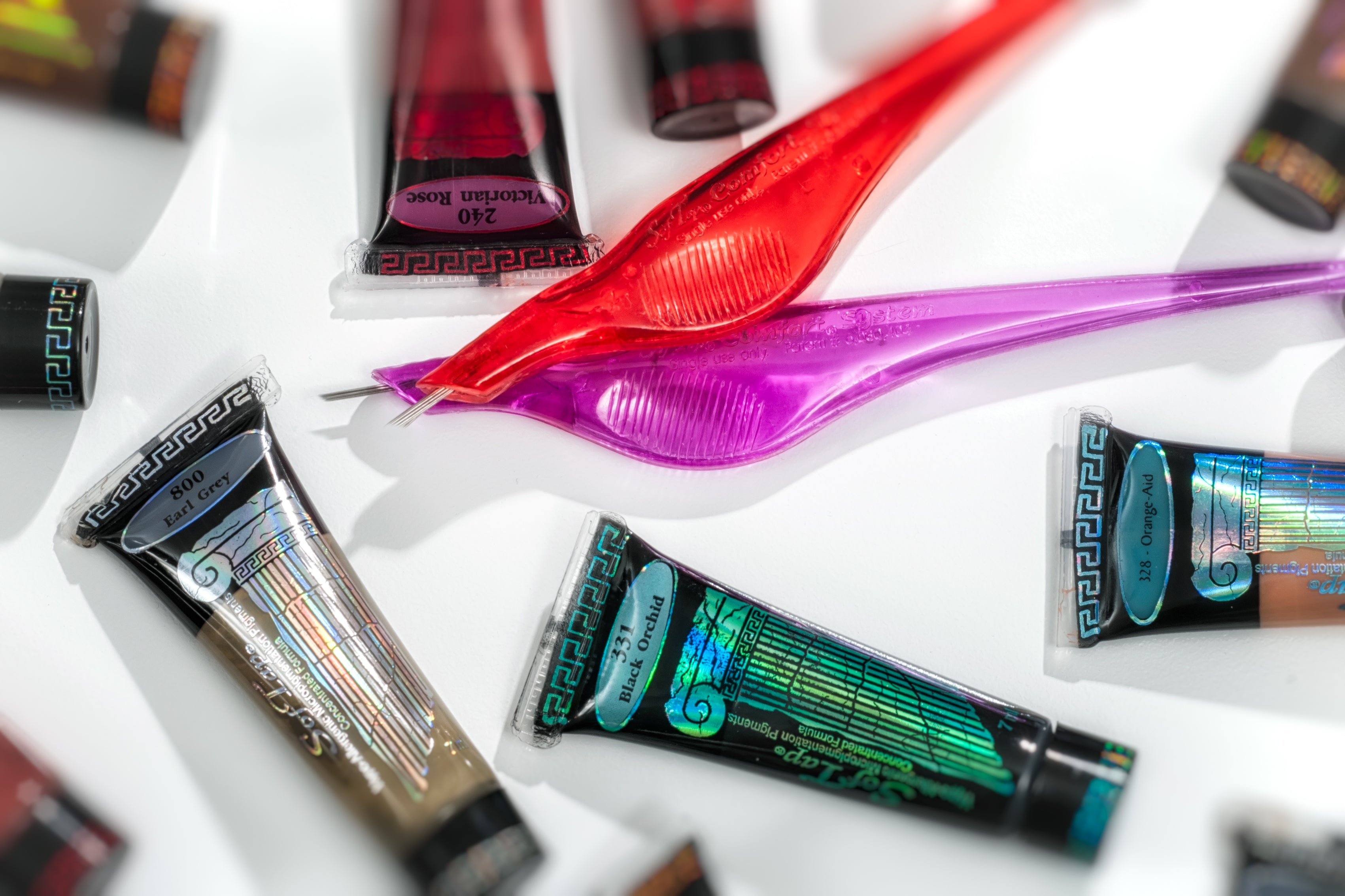 SofTap pigment tubes and red pink needles with white background