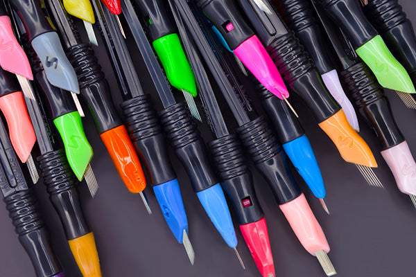 Lots of SofTap Click tip disposable needles with all colors on black handles with black background