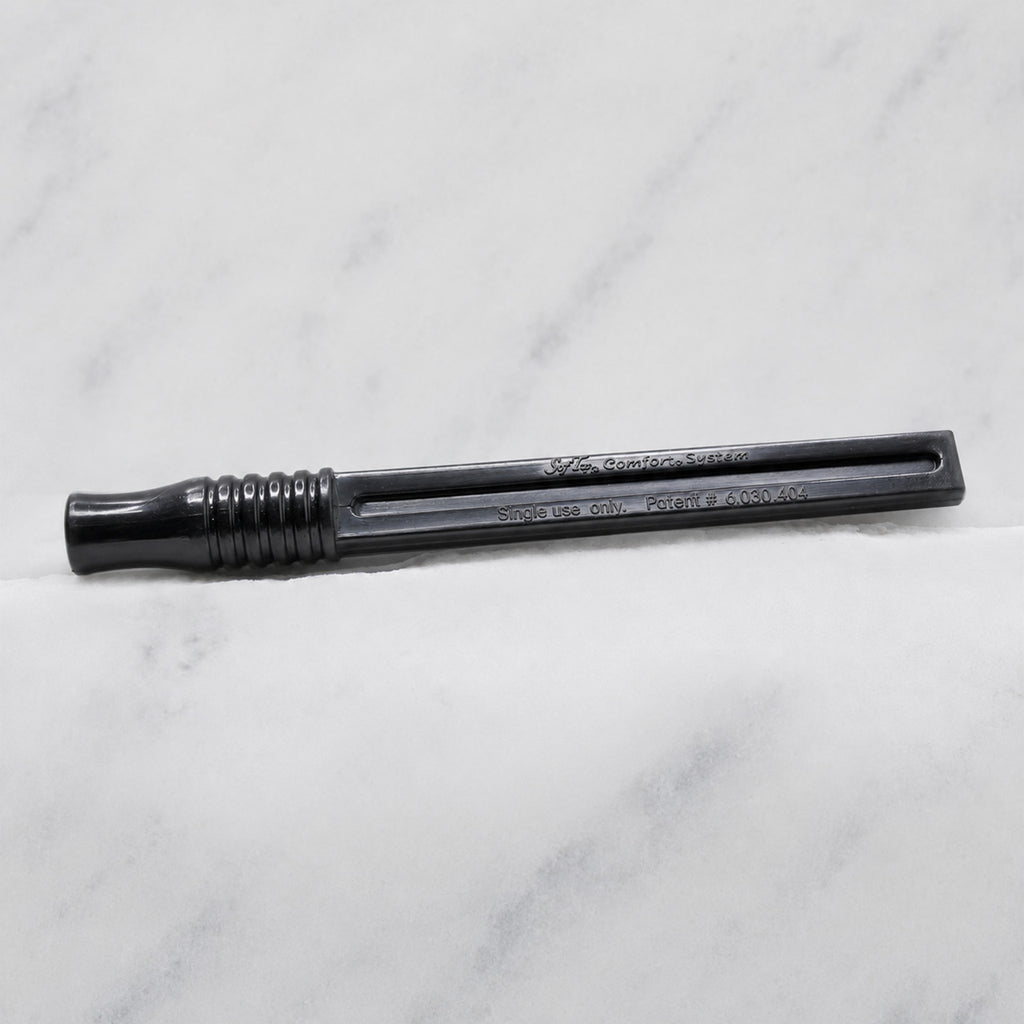 A close-up of SofTap pmu click stick handle, resting on a white marble surface.