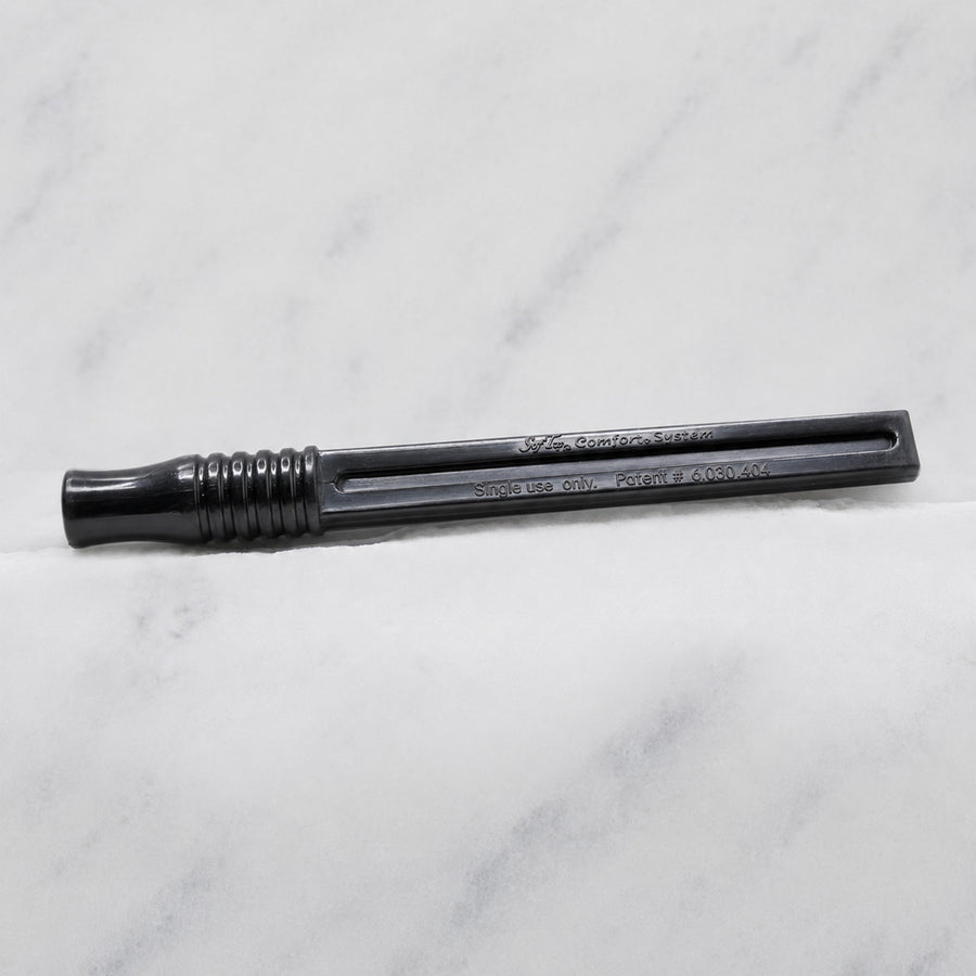 A close-up of SofTap pmu click stick handle, resting on a white marble surface.