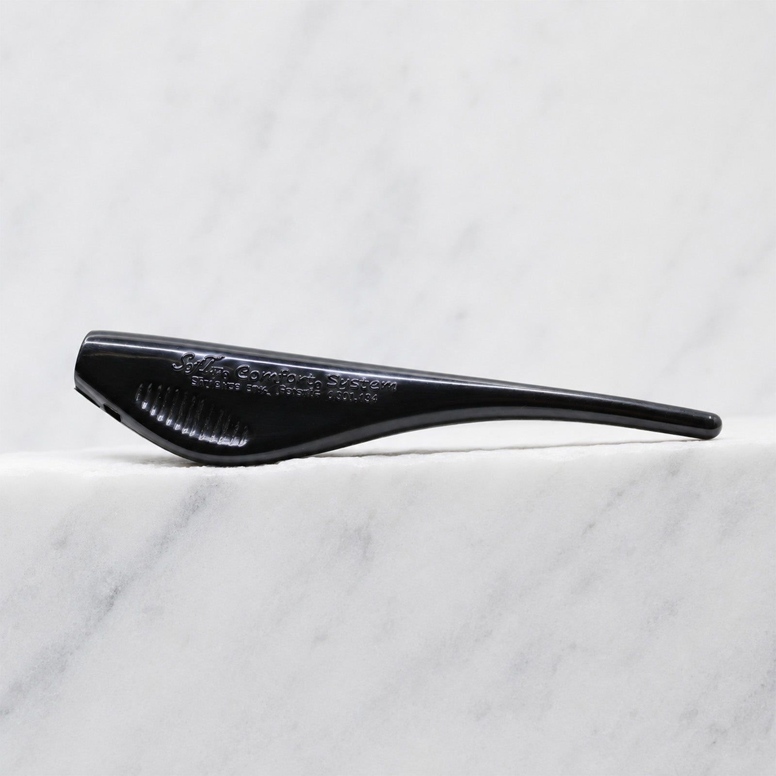 A close-up of SofTap comfort fish stick handle, resting on a white marble surface.