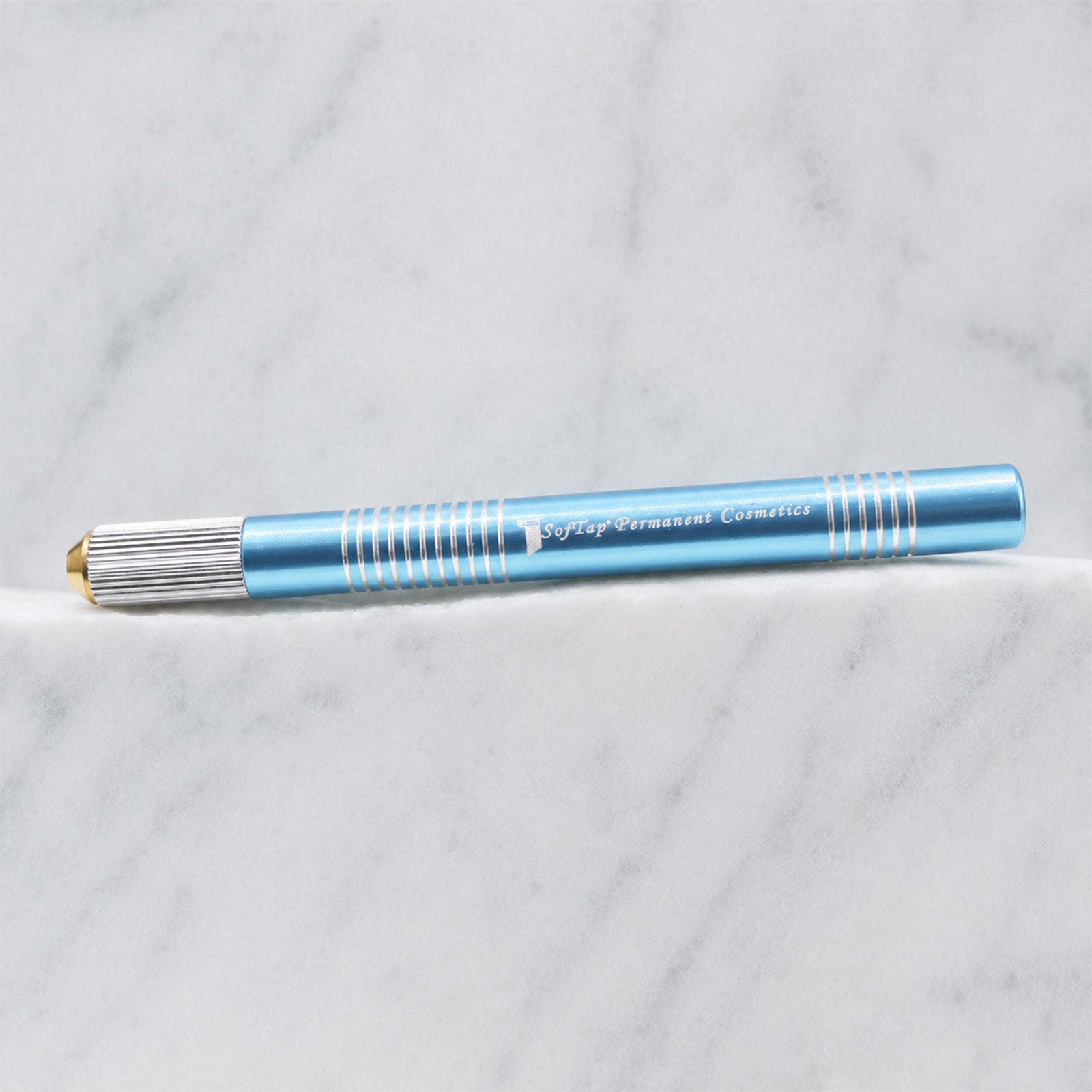 A close-up of SofTap large metal handle for foil cartridge needles, resting on a white marble surface.