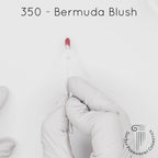 white gloved hand with white brush smearing SofTap natural pink Bermuda Blush Color for permanent lips