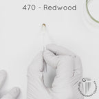 white gloved hand with white brush smearing SofTap dark warm medium brown Redwood Color for permanent eyebrows