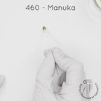 white gloved hand with white brush smearing SofTap medium blonde Manuka Color for permanent eyebrows
