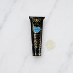 SofTap aftercare healing product Recoverall tube with blob of off-white oitment on white marble background