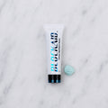 SofTap topical anesthetic Blockaid tube with blob of blue cream on white marble background
