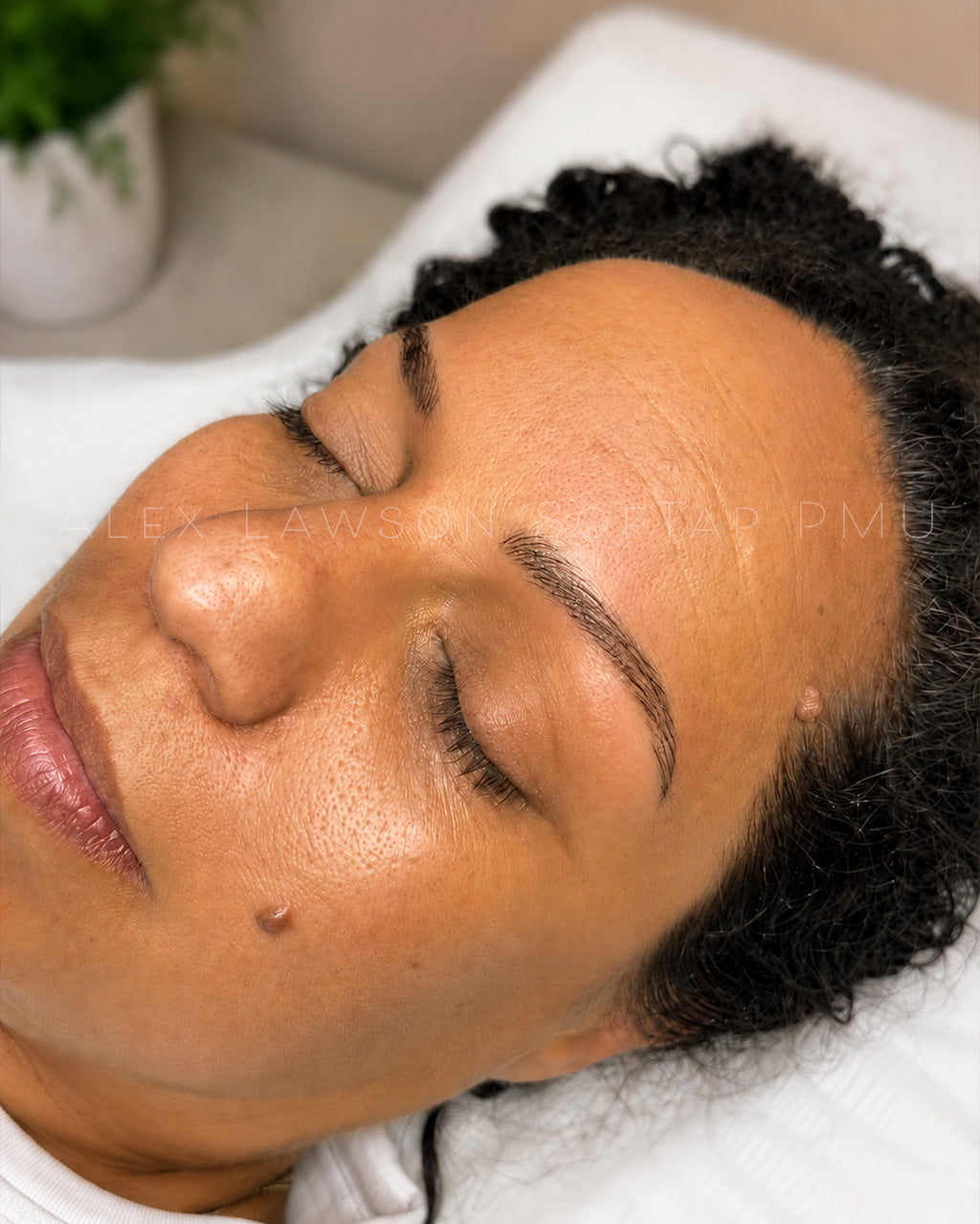 Close-up of a client with softap nano brow hairstroke permanent makeup with a blurred background