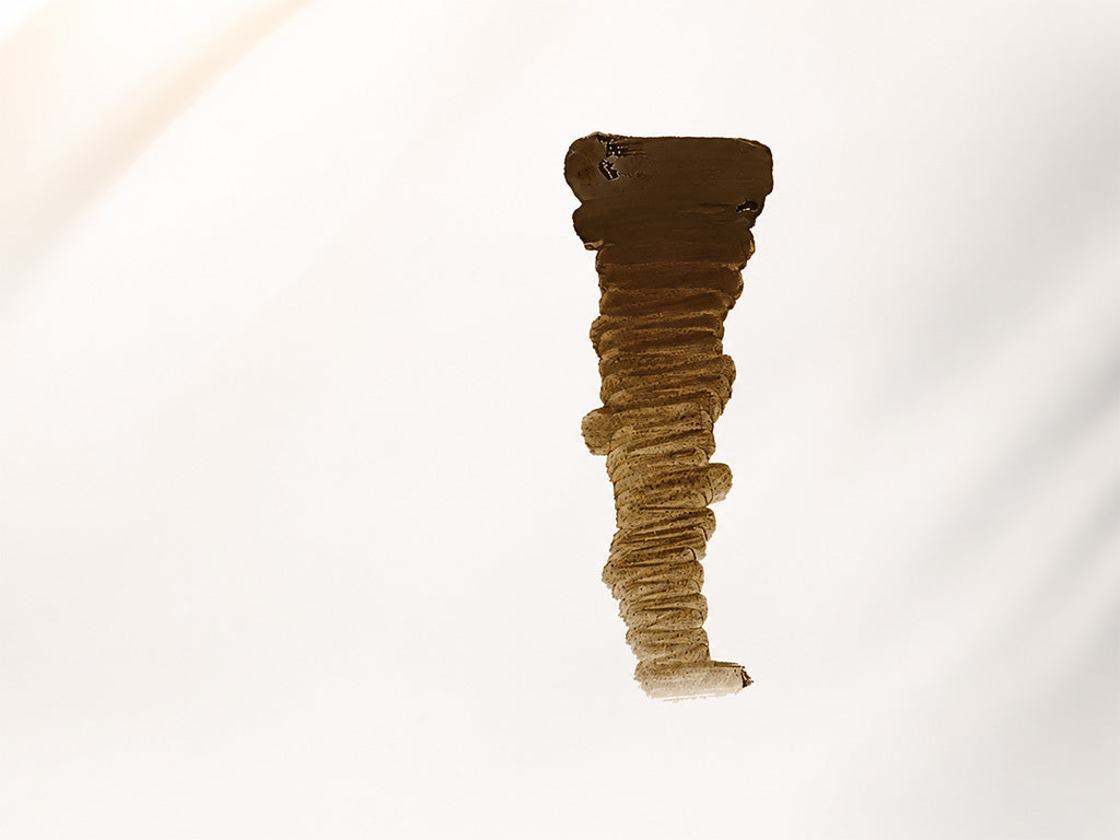 Brown textured eyebrow pigment drawdown on a white background