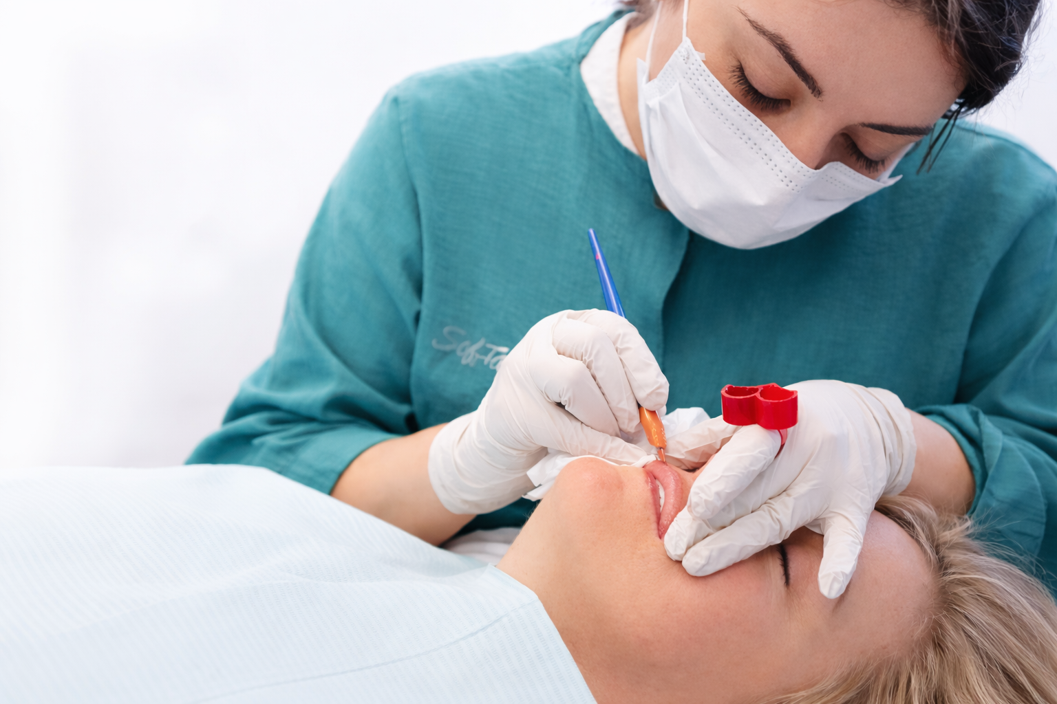 Professional SofTap artist performing hand method lip blush procedure with precision technique.