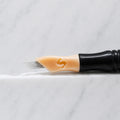 A close-up of SofTap 11 ultimate pmu needle click tip, resting on a white marble surface.