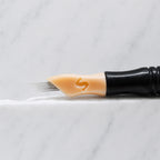 A close-up of SofTap 11 ultimate pmu needle click tip, resting on a white marble surface.