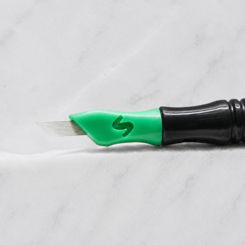 A close-up of SofTap 12 pmu needle click tip, resting on a white marble surface.
