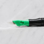 A close-up of SofTap 12 pmu needle click tip, resting on a white marble surface.
