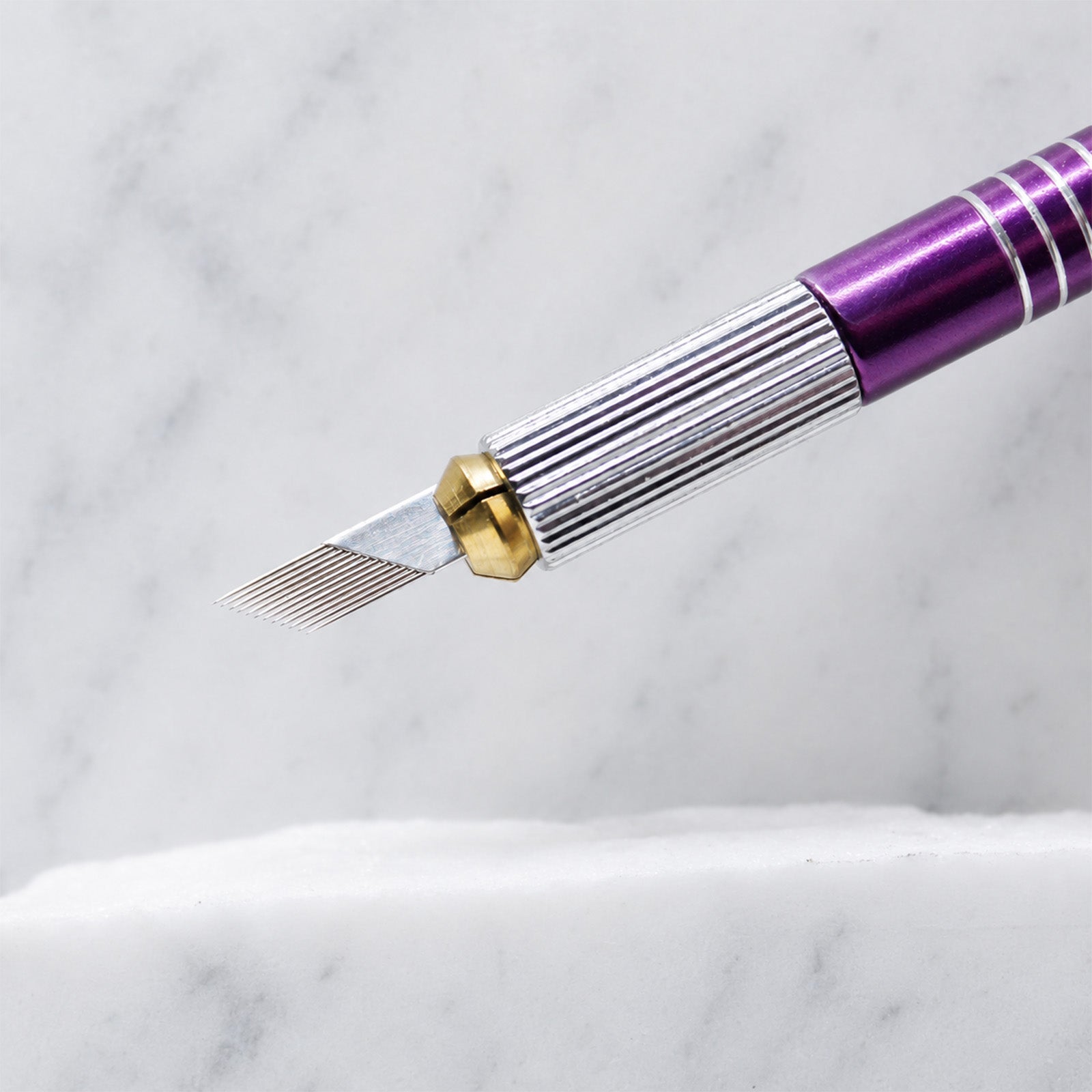 A close-up of SofTap 12 pmu needle foil cartridge, resting on a white marble surface.