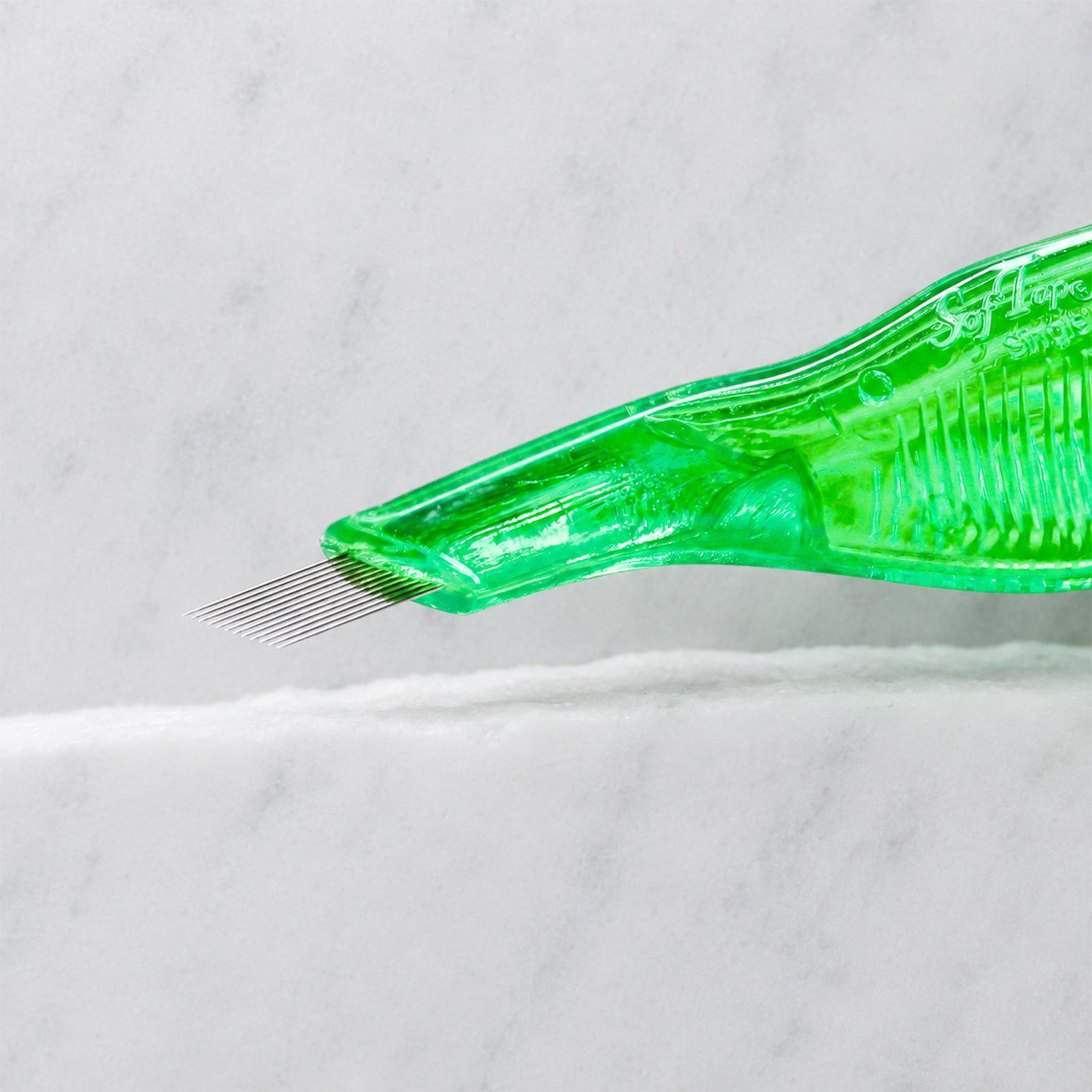 A close-up of SofTap 12 pmu needle disposable pen, resting on a white marble surface.