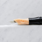A close-up of SofTap 13 smudger pmu needle click tip, resting on a white marble surface.