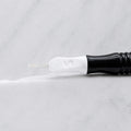 A close-up of SofTap 13 u nano pmu needle click tip, resting on a white marble surface.