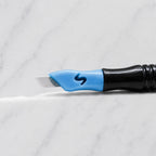 A close-up of SofTap 14 curve pmu needle click tip, resting on a white marble surface.