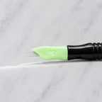 A close-up of SofTap 114 ultimate smudger pmu needle click tip, resting on a white marble surface.
