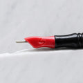 A close-up of SofTap 15 round pmu needle click tip, resting on a white marble surface.