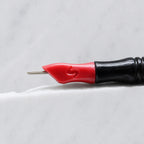 A close-up of SofTap 15 round pmu needle click tip, resting on a white marble surface.