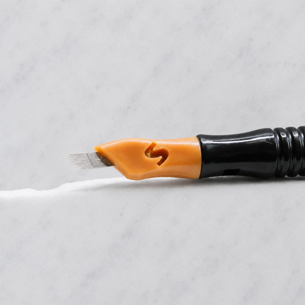 A close-up of SofTap 16 curve pmu needle click tip, resting on a white marble surface.