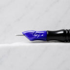 A close-up of SofTap 18 round pmu needle click tip, resting on a white marble surface.
