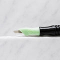 A close-up of SofTap 20 smudger pmu needle click tip, resting on a white marble surface.