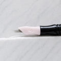 A close-up of SofTap 20 ultimate smudger pmu needle click tip, resting on a white marble surface.