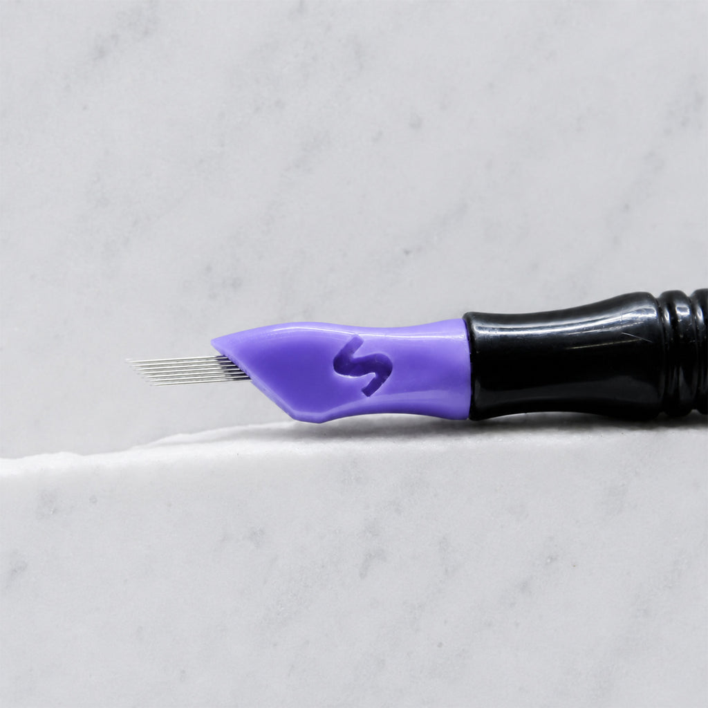 A close-up of SofTap 23 smudger pmu needle click tip, resting on a white marble surface.