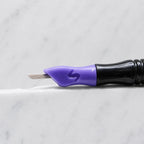 A close-up of SofTap 25 round pmu needle click tip, resting on a white marble surface.