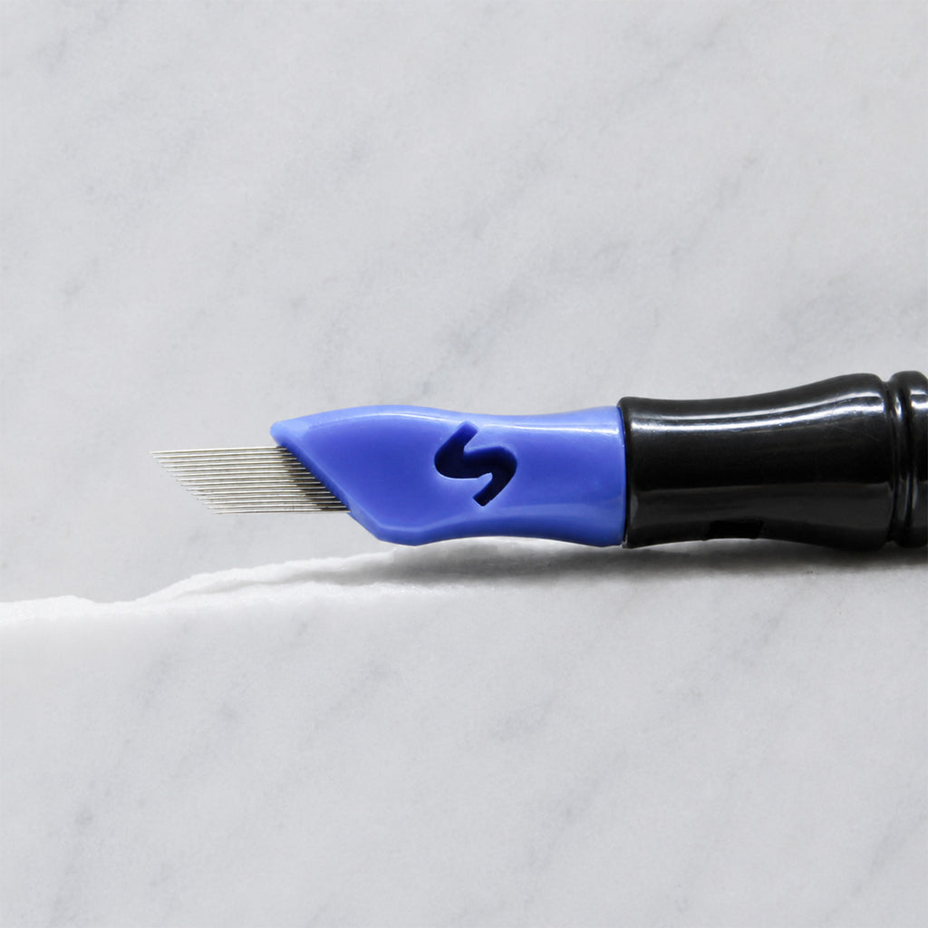 A close-up of SofTap 28 pmu needle click tip, resting on a white marble surface.
