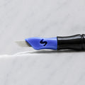 A close-up of SofTap 28 pmu needle click tip, resting on a white marble surface.