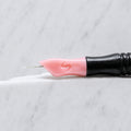 A close-up of SofTap 3 round pmu needle click tip, resting on a white marble surface.