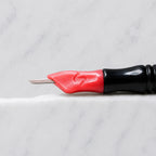 A close-up of SofTap 33 round pmu needle click tip, resting on a white marble surface.