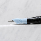 A close-up of SofTap 36 round pmu needle click tip, resting on a white marble surface.