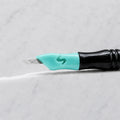 A close-up of SofTap 39 pmu needle click tip, resting on a white marble surface.