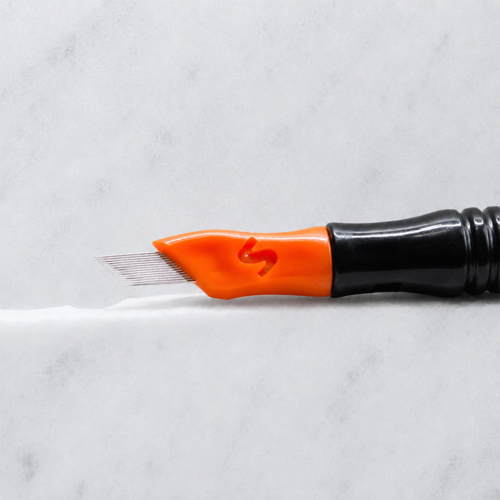 A close-up of SofTap 42 pmu needle click tip, resting on a white marble surface.