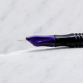 A close-up of SofTap 5 pmu needle click tip, resting on a white marble surface.