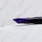 A close-up of SofTap 5 pmu needle click tip, resting on a white marble surface.