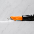 A close-up of SofTap 56 pmu needle click tip, resting on a white marble surface.