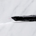 A close-up of SofTap 6 reg curve pmu needle click tip, resting on a white marble surface.