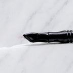 A close-up of SofTap 6 reg curve pmu needle click tip, resting on a white marble surface.