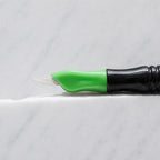 A close-up of SofTap 7 smudger pmu needle click tip, resting on a white marble surface.