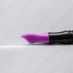 A close-up of SofTap 8 round pmu needle click tip, resting on a white marble surface.