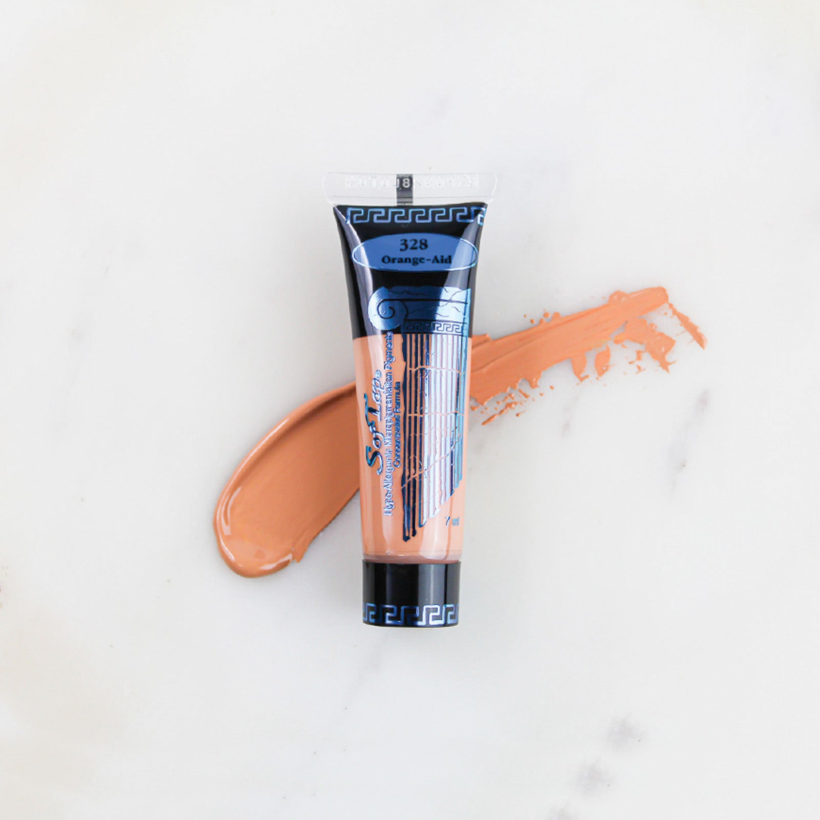 SofTap permanent makeup pigment Orange-Aid tube with color swatch on marble background