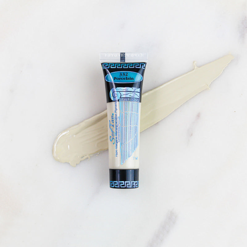 SofTap permanent makeup pigment Porcelain tube with color swatch on marble background